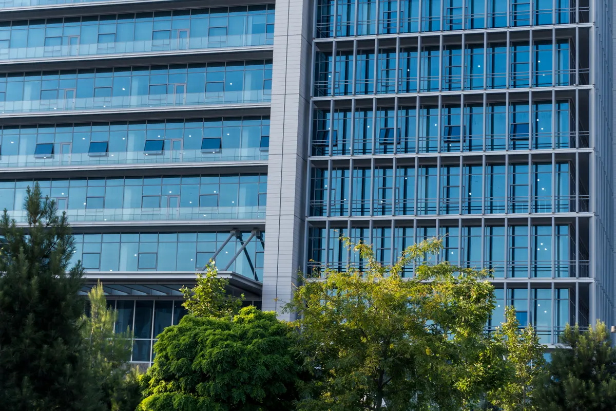 Modern office building with blue glass windows and landscaped grounds